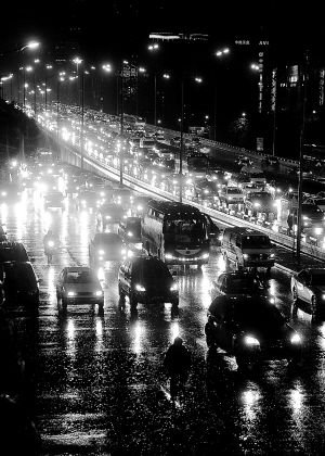 11月3日傍晚，北京西三環主輔路上的車輛在雨中緩慢行駛。本版照片：新華社發
